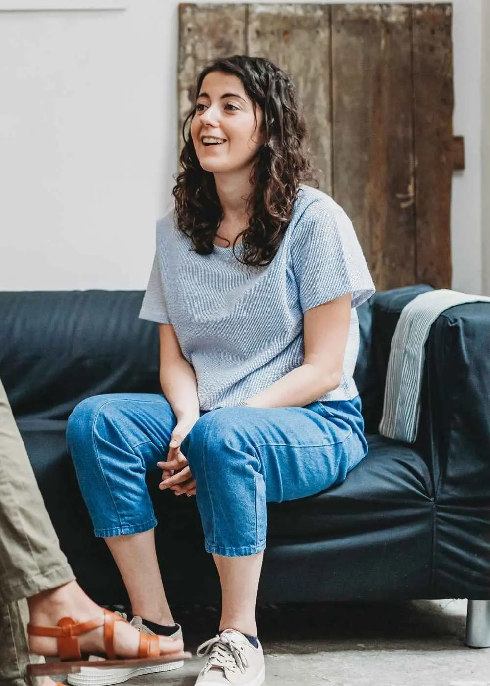 Woman sitting on a couch engaged in conversation during inpatient therapy