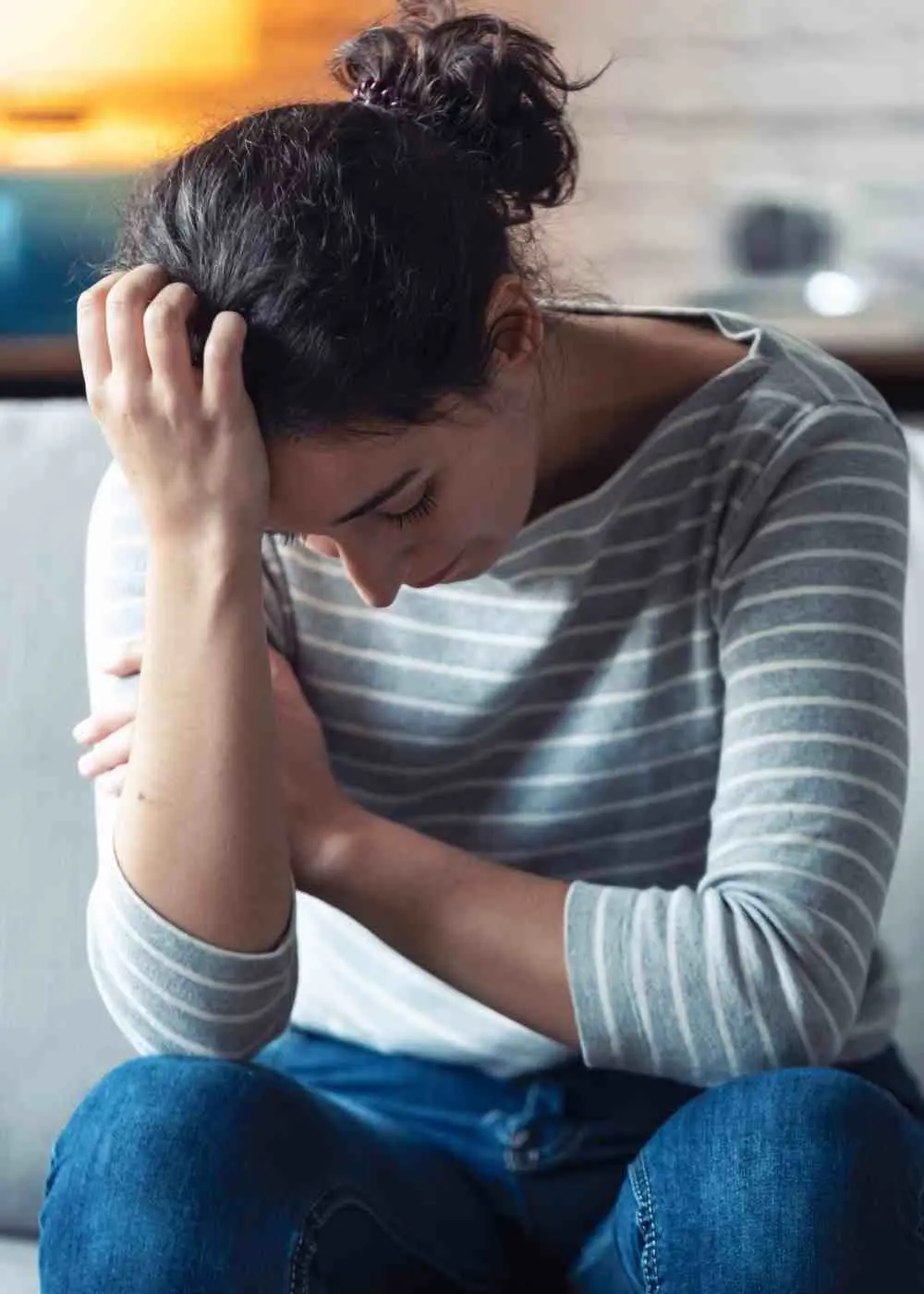 Woman sitting with head down feeling overwhelmed and emotionally drained from depression