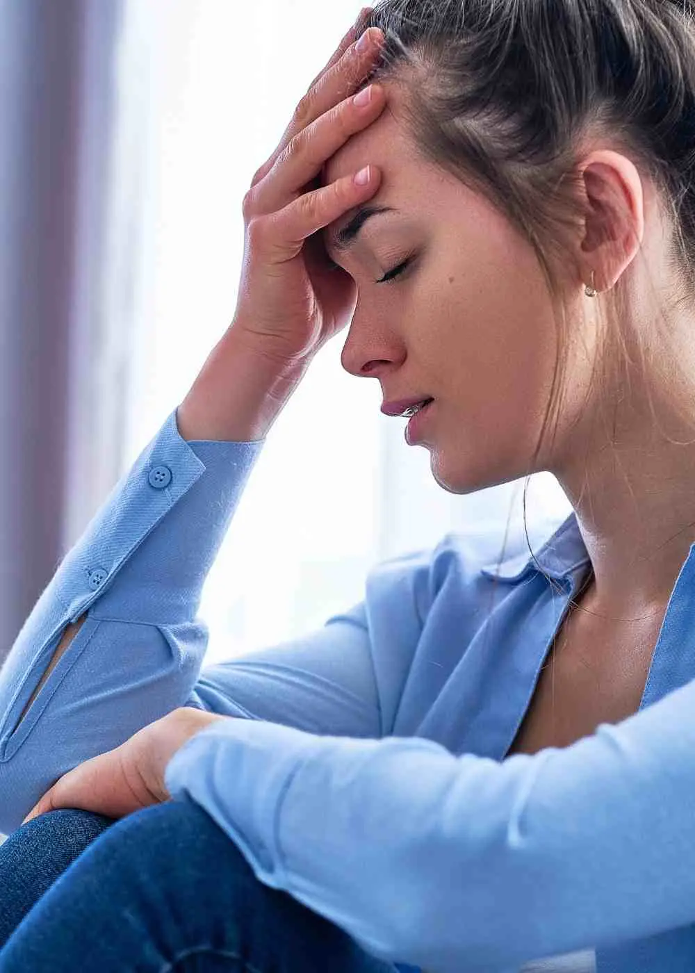 Woman holding her head feeling overwhelmed by negative thoughts and depression