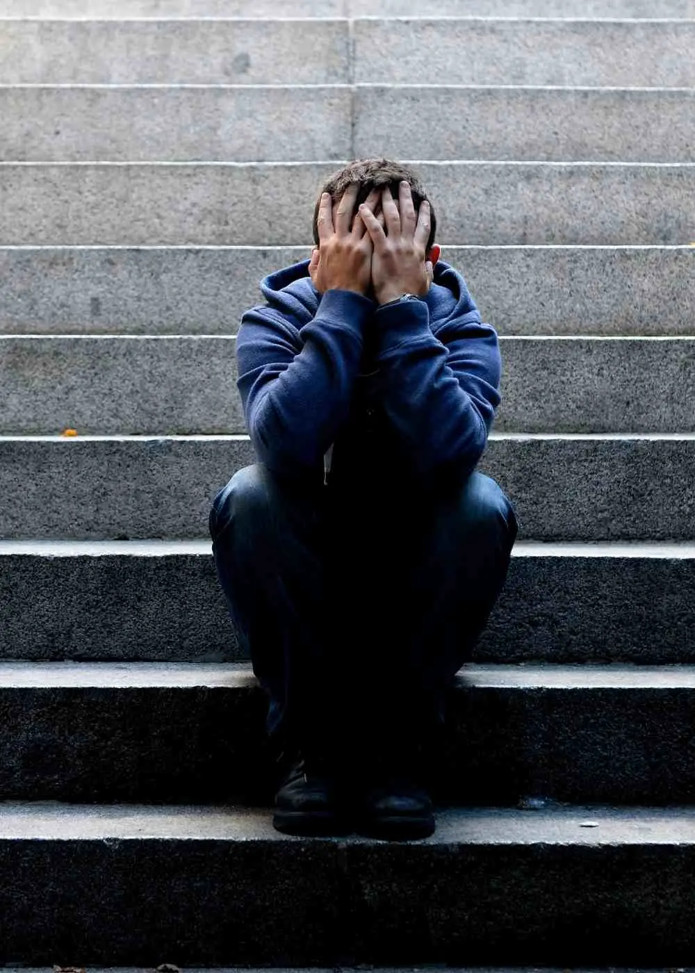 Wan sitting on stairs covering face showing emotional distress and high-functioning depression symptoms